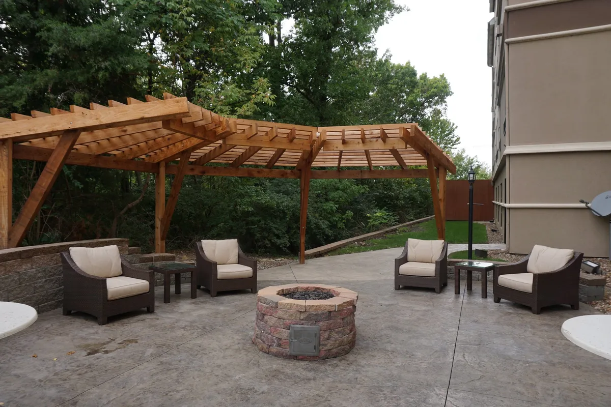 Depicted here is a wooden pergola with a cozy fire pit and comfortable seating area, ideal for intimate gatherings or unwinding after a day exploring the city. The evening lighting and inviting arrangement create a warm, romantic ambiance that appeals to couples seeking relaxation and leisure.