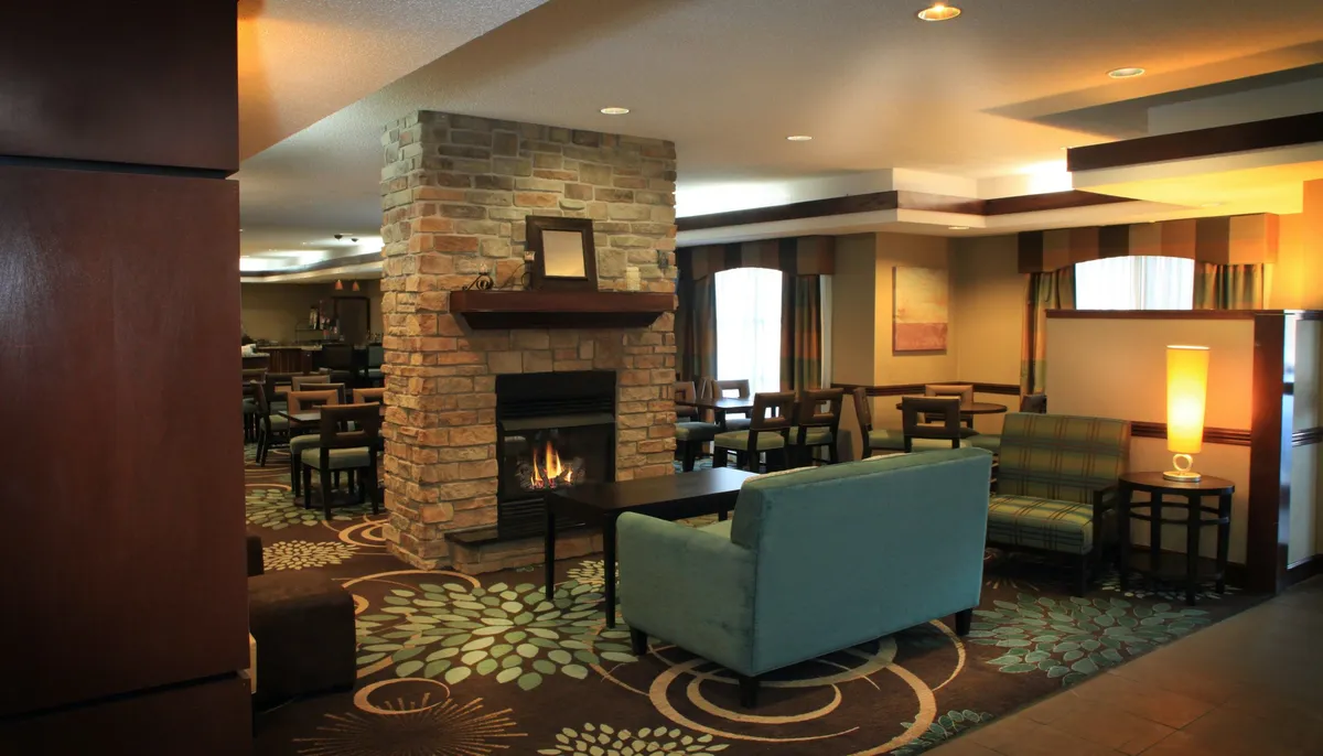 A warm, inviting living area with a fireplace, comfortable seating area, and a decorative rug. The atmosphere suggests a perfect setting for unwinding, reading, or spending time with family.